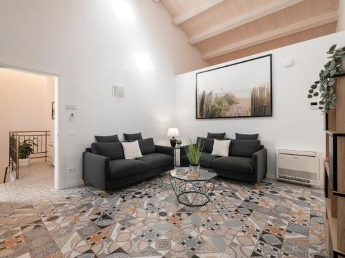 a living room with two couches and a table at Zuara9Room Rimini in Rimini
