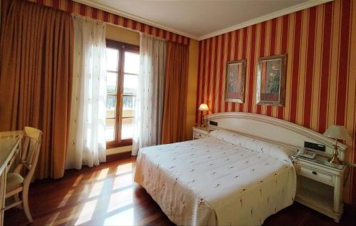 a bedroom with a large bed and a window at Hotel Conde Ansúrez in Valladolid