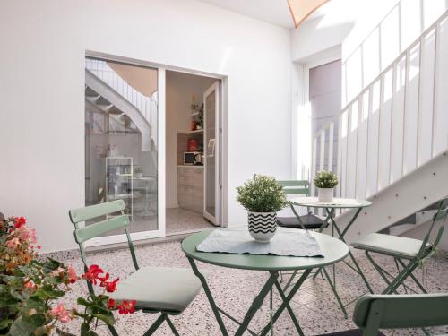 a balcony with two tables and chairs and a staircase at Zuara9Room Rimini in Rimini