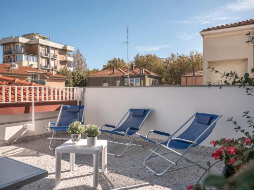 a patio with chairs and a table on a balcony at Zuara9Room Rimini in Rimini