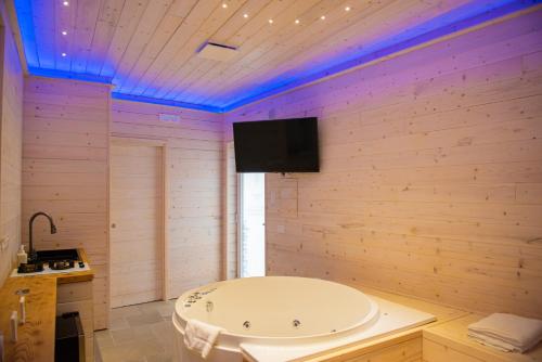 een badkamer met een bad en een tv aan de muur bij ARTEMIDE "Corte Segreta" B&B SUITE SPA in San Cipriano Picentino