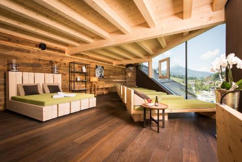 a bedroom with two beds and a table at Hotel Der Löwe LEBE FREI in Leogang