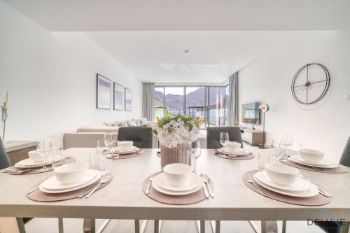 a dining room with a table with plates and glasses at Exclusive Deal! Luxury 4BR Villa on Al Dana Island by Deluxe Holiday Homes in Fujairah