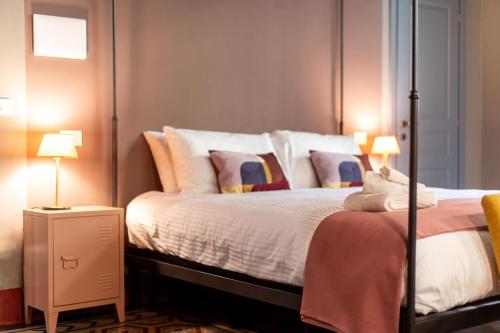 a bedroom with a large bed with two lamps at Casa Leopoldo in Pisa
