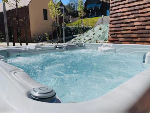 un bain à remous avec de l'eau dans l'arrière-cour dans l'établissement Le Viagio Superbe appartement avec jacuzzi, à Sarlat-la-Canéda