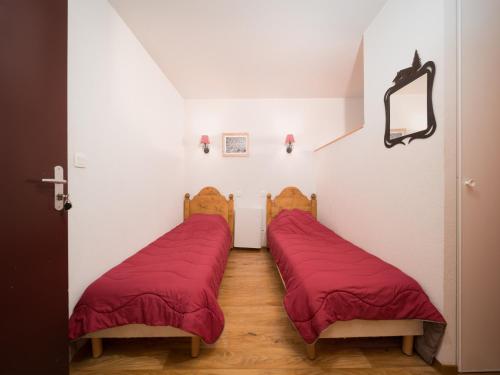 - 2 lits dans une chambre avec des draps rouges dans l'établissement CENTRAL PARK 208 - Appt Montagne 4 pers, à Allos