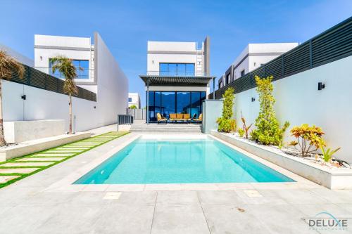 a swimming pool in the backyard of a house at Exclusive Deal! Luxury 4BR Villa on Al Dana Island by Deluxe Holiday Homes in Fujairah