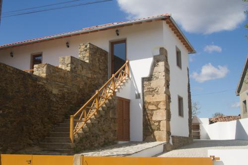 a white house with a stone wall and stairs at A Casa de Salsas in Salsas
