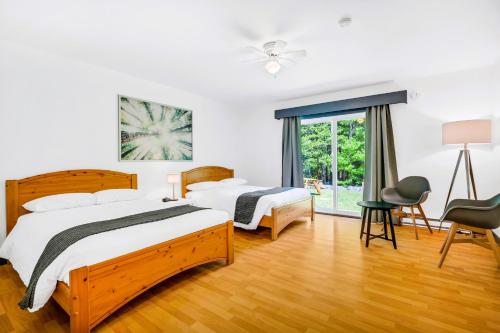 a bedroom with two beds and a window at Mersey River Chalets a nature retreat in Caledonia