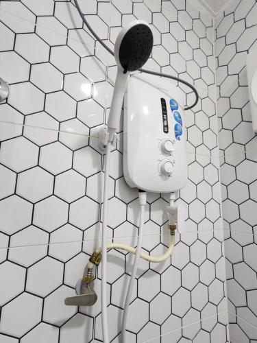 a shower in a bathroom with white tiles at Sun Star Home by Ipoh Maju Stay in Ipoh