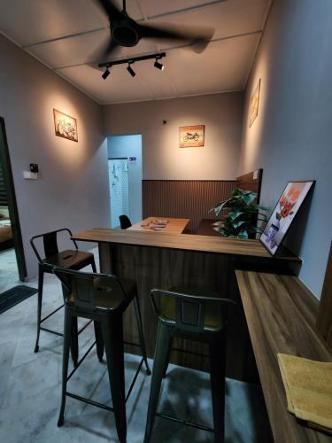 a bar in a restaurant with two chairs at Sun Star Home by Ipoh Maju Stay in Ipoh