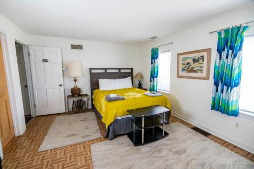 a bedroom with a bed with a yellow blanket at The Bridges Mt Washington Sleeps 12 in Pittsburgh