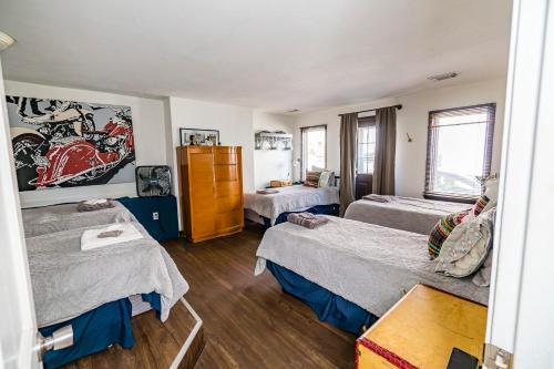 a room with three beds and a painting on the wall at The Bridges Mt Washington Sleeps 12 in Pittsburgh