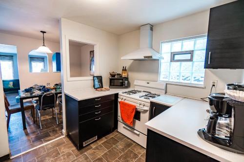 a kitchen with a stove top oven next to a table at The Bridges Mt Washington Sleeps 12 in Pittsburgh