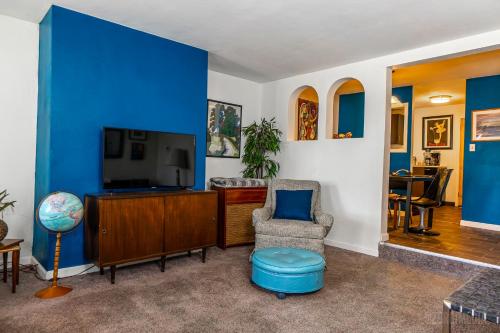 a living room with blue walls and a chair and a tv at The Bridges Mt Washington Sleeps 12 in Pittsburgh