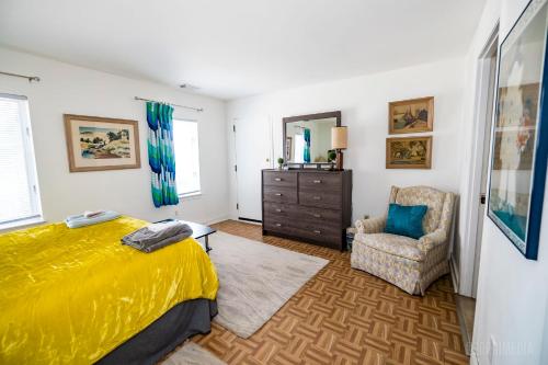 um quarto com uma cama amarela e uma cadeira em The Bridges Mt Washington Sleeps 12 em Pittsburgh