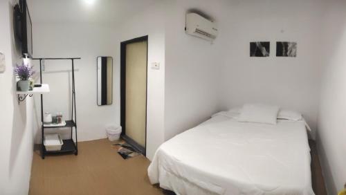 a bedroom with a white bed in a room at Bulat Cottage in Pantai Cenang