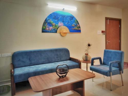 Una sala de estar con un sofá azul y una mesa. en Symphony Apartments at MIHAN Nagpur, en Nagpur