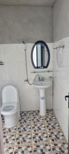 a bathroom with a toilet and a sink and a mirror at Hoàng nam Homestay in Quang Ba