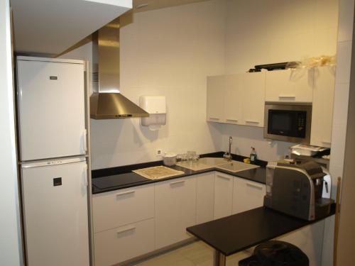 a kitchen with white cabinets and a refrigerator at Koikili Aterpetxea in Ochandiano