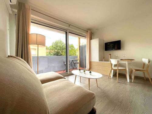 un salon avec un canapé et une table dans l'établissement Charmant Studio Beaux Arts avec Clim et terrasse, à Montpellier