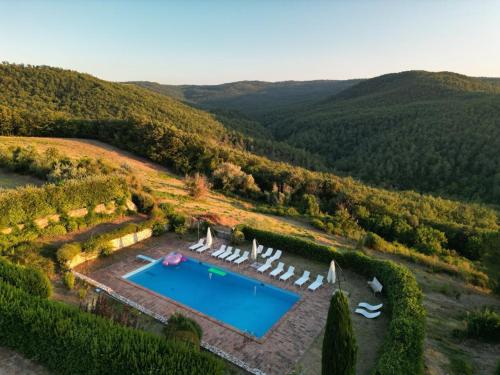 einen Luftblick auf einen Pool mit Liegestühlen in der Unterkunft Tenuta Acquabona - Appartamento 1 in Gambassi Terme