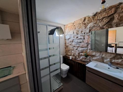 a bathroom with a sink and a stone wall at Apartamento Clau in Puigmoreno