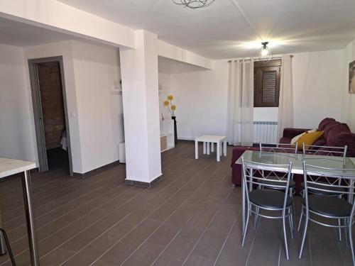 a living room with a table and chairs and a couch at Apartamento Clau in Puigmoreno