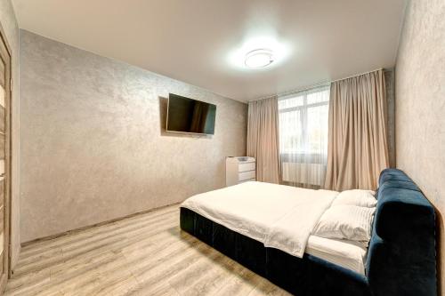um quarto com uma cama e uma televisão na parede em Apartment Voskresenska 18 , Парковые Озера em Kiev