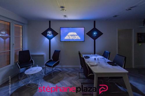 une salle à manger avec une table et une télévision au mur dans l'établissement Plaza Star Wars Appartement, à Serris