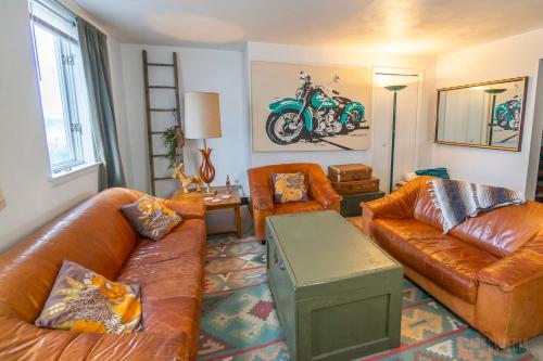 a living room with leather couches and a motorcycle on the wall at Southwest Charming Apartment - Amazing View in Pittsburgh