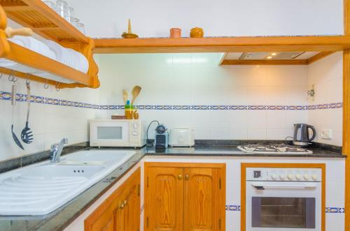 a kitchen with a sink and a microwave at Garonda Villa in Cala Pi