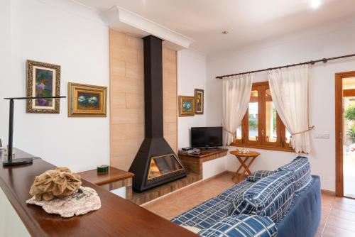 a living room with a couch and a fireplace at Garonda Villa in Cala Pi