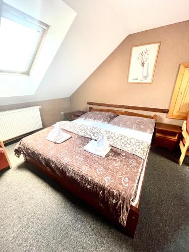 a bedroom with a bed with two towels on it at Penzion a restaurace U Nováků in Bítovany