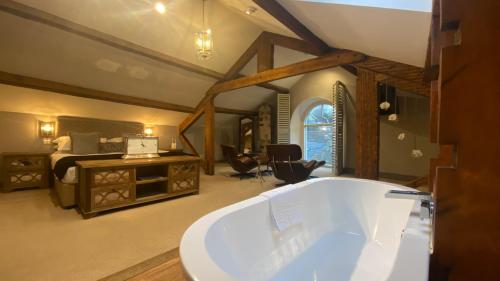 a bath tub in a room with a bedroom at The Coach House Skipton in Skipton