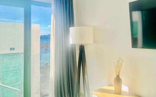 una lámpara sentada en una habitación junto a una ventana en Canaryislandshost l Cala, en Punta Mujeres