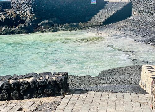 un cuerpo de agua junto a un camino de piedra junto al océano en Canaryislandshost l Cala, en Punta Mujeres