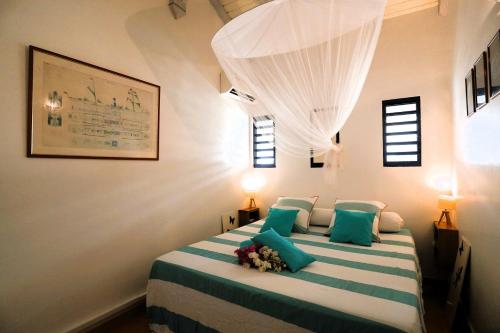 um quarto com uma cama grande e almofadas azuis em Le Lagon d'Anolis em Sainte-Anne