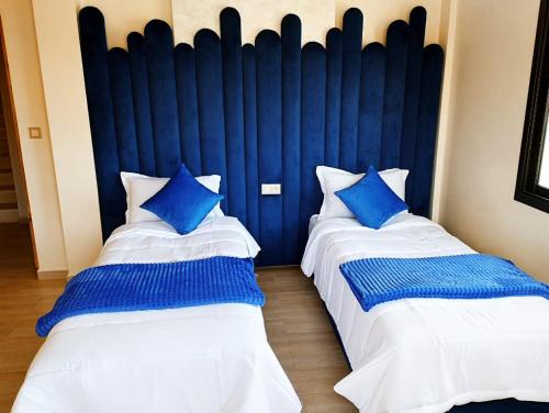 two beds in a room with blue and white at Incantevole villa Safi Sidi Bouzid near beach in Safi