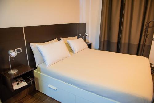 a bedroom with a large bed with white sheets and pillows at ARTEMIDE "Fiore Club" B&B SUITE SPA in Giffoni Valle Piana