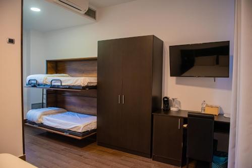 a bedroom with two bunk beds and a desk at ARTEMIDE "Fiore Club" B&B SUITE SPA in Giffoni Valle Piana