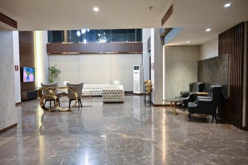 a lobby with chairs and a table in a building at Jacaranda Heights in Islamabad