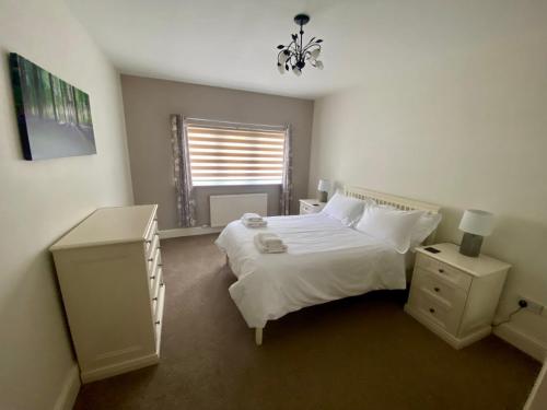 a bedroom with a white bed and a window at Calder Cottage in The Ribble Valley in Whalley