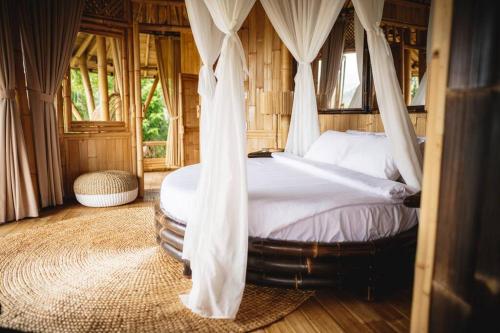 um quarto com uma cama com redes mosquiteiras em The Nude House em Selat