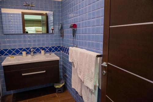 a blue tiled bathroom with a sink and a mirror at ARTEMIDE "Fiore Club" B&B SUITE SPA in Giffoni Valle Piana