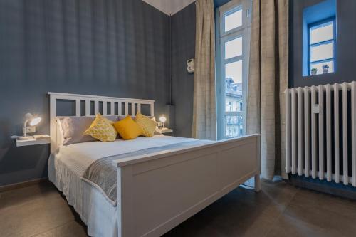 een slaapkamer met een bed met gele kussens en een raam bij Einaudi Apartment by Wonderful Italy in Turijn