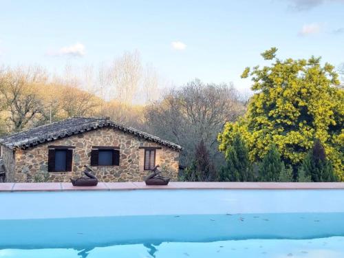 una casa de piedra con una piscina frente a ella en FINCA LA LISERILLA, en Galaroza