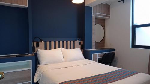 - une chambre dotée d'un lit avec un mur bleu dans l'établissement La Casa de Justi, à Huancayo