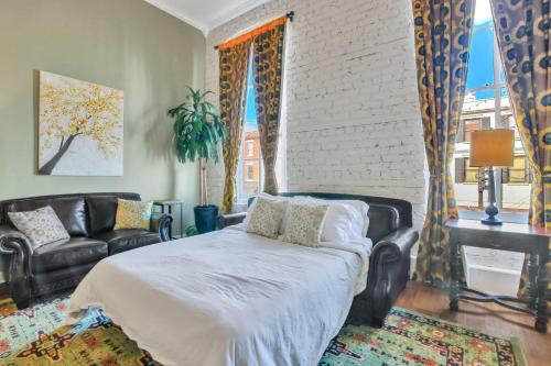 - une chambre avec un lit, un canapé et une fenêtre dans l'établissement Broughton Retreat, à Savannah