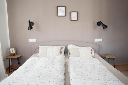 um quarto com uma cama com duas almofadas e duas mesas em Schlaf-Scheune auf Islandpferdehof im Grünen em Steinau an der Straße